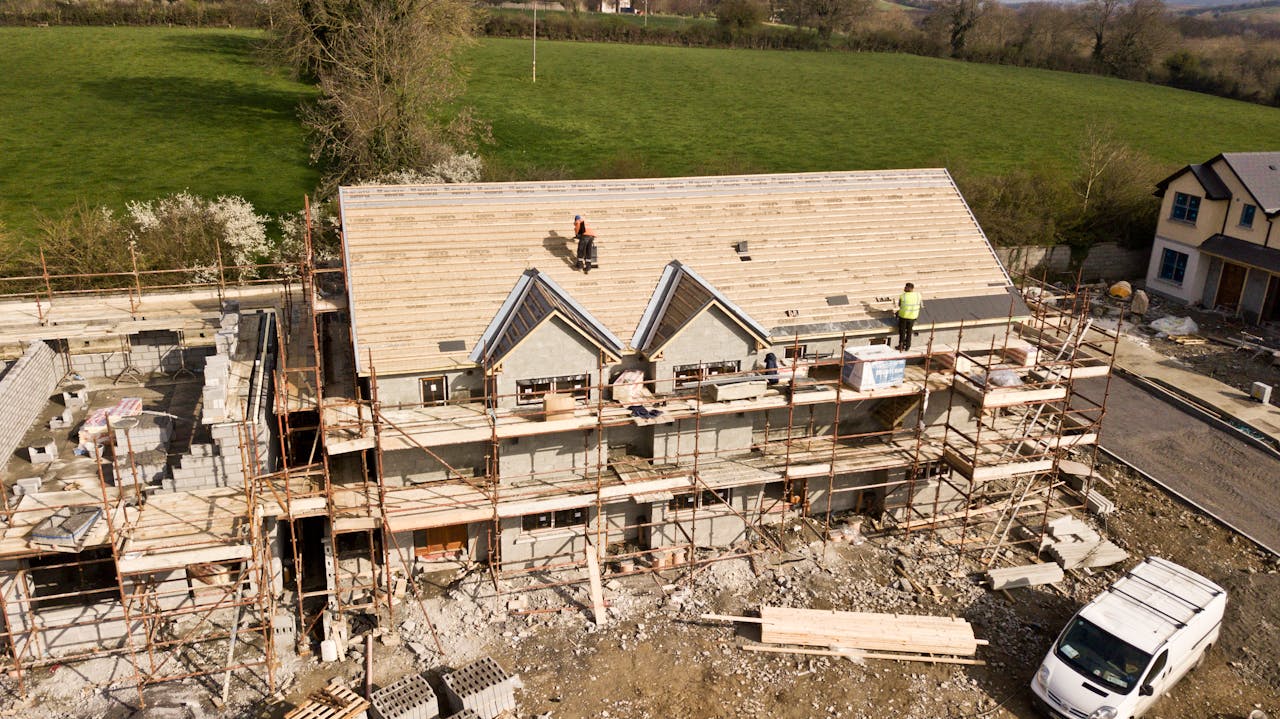 who-we-are Aerial shot of a house under construction in Clonmel, Ireland. Workers on the roof.